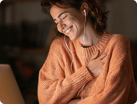 Happy woman with earphones touching her chest, health monitoring.