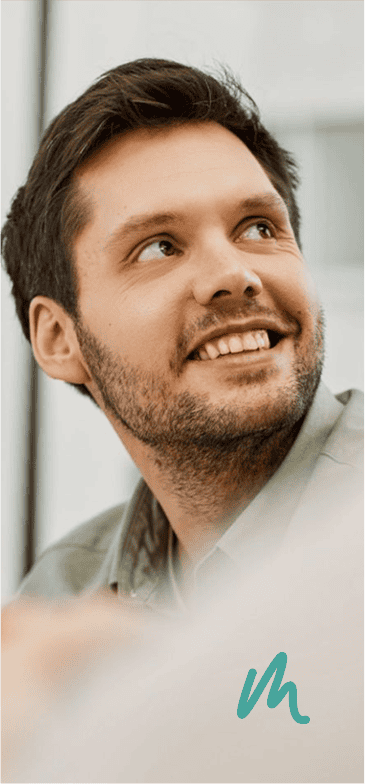 Smiling man looking up, using Med Mend health app on smartphone.